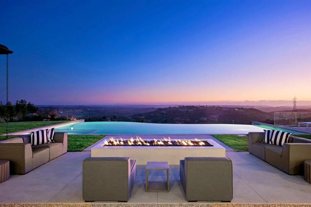 Infinity-edge pool and fire feature overlooking the San Diego hills at twilight